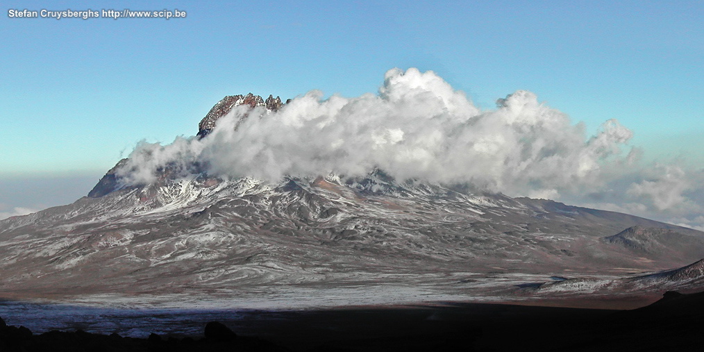 Kilimanjaro - Dag 4 - Mawenzi vanaf Kibo Zicht op Mawenzi vanaf de Kibohut. In de namiddag en vooravond probeer je nog wat te slapen. Omstreeks 23.00 uur begint iedereen zich warm aan te kleden en voor te bereiden op de laatste rush naar de top. In het donker vertrekt een hele karavaan van toeristen naar boven. Het is vermoeiend stappen in het mulle zand en gruis, ademen wordt echt wel moeilijk en heel wat mensen krijgen last van hoogteziekte (duizeligheid, hoofdpijn, braken).  Stefan Cruysberghs